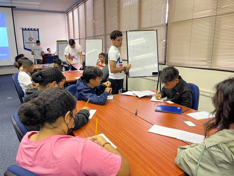 Mesa llena de estudiantes estudiando matemáticas